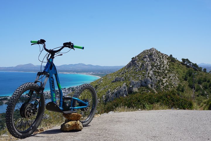 Una bicicleta está estacionada sobre una roca al costado de una carretera.