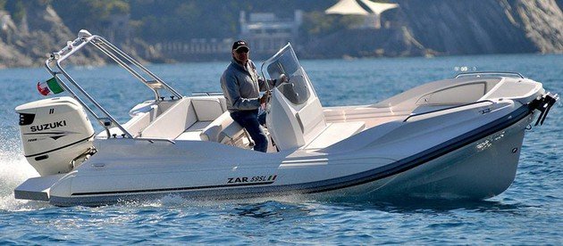 Un hombre conduce un barco blanco en el océano.