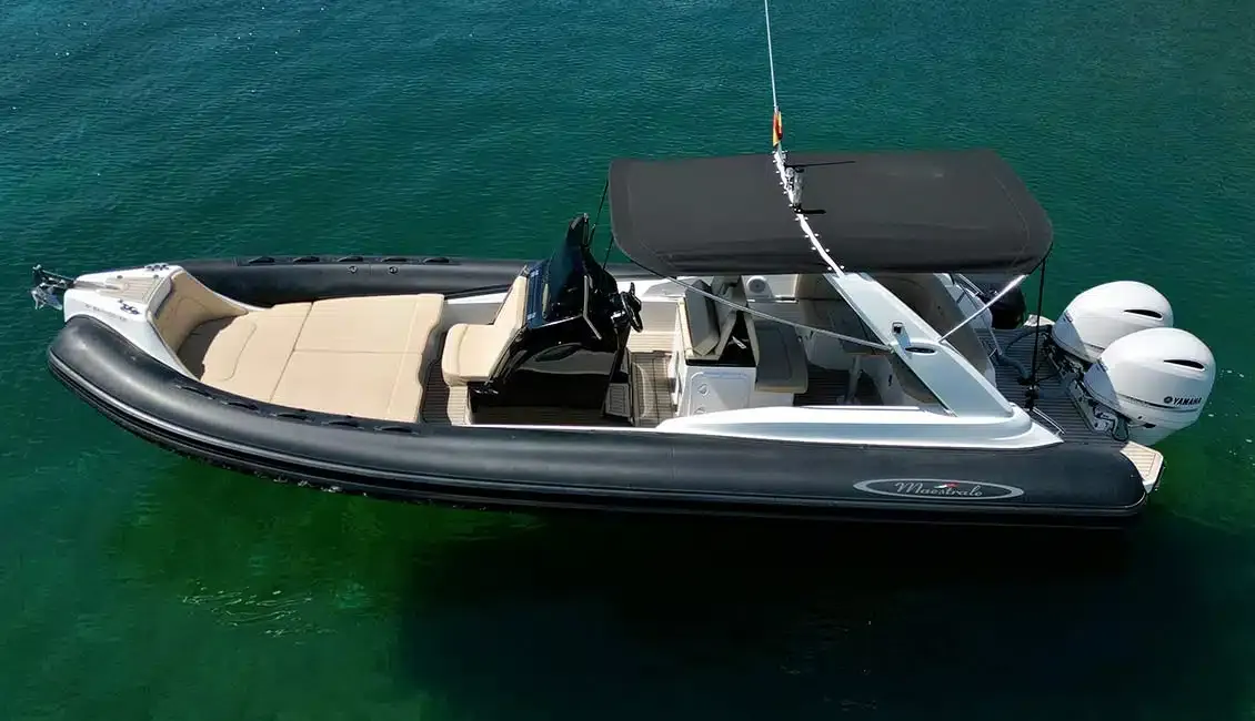 Un barco blanco y negro flota sobre un cuerpo de agua.