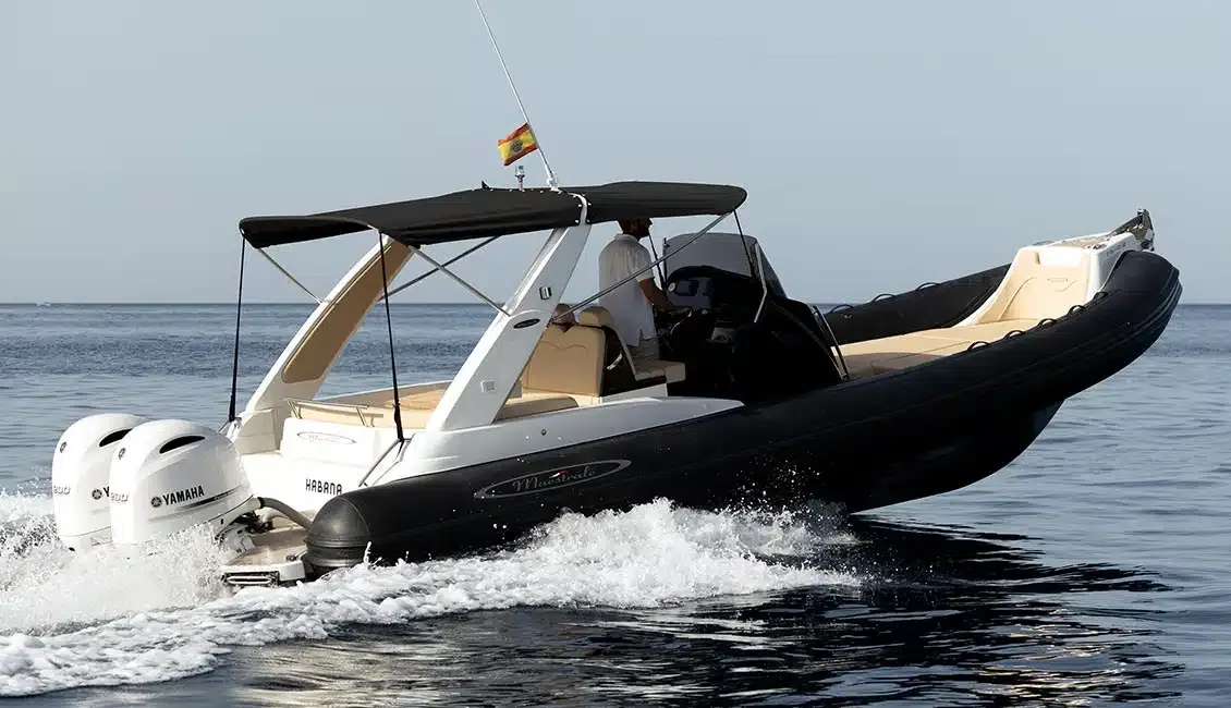 Un barco blanco y negro flota sobre un cuerpo de agua.