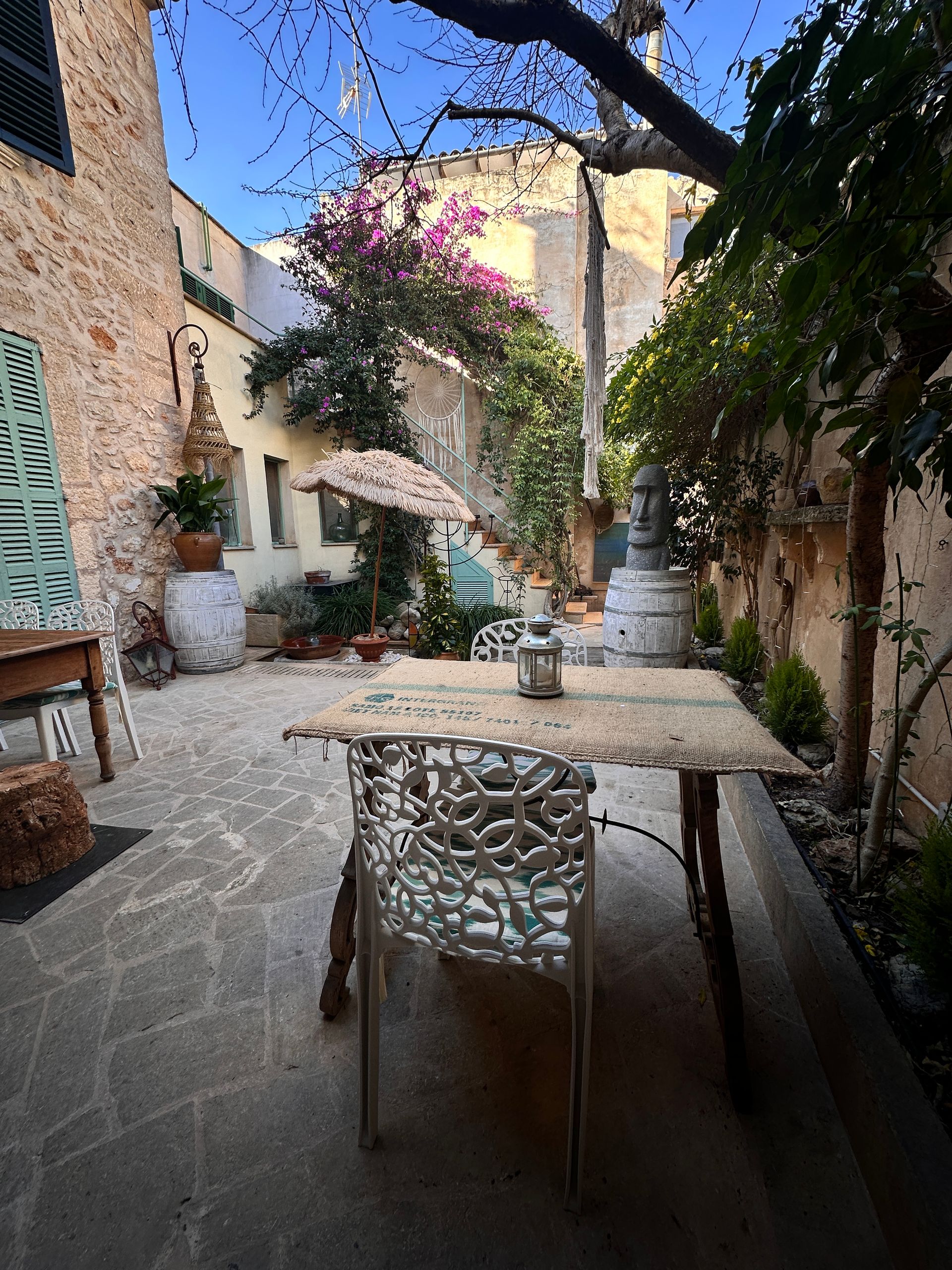 Un patio con una mesa y sillas frente a un edificio.