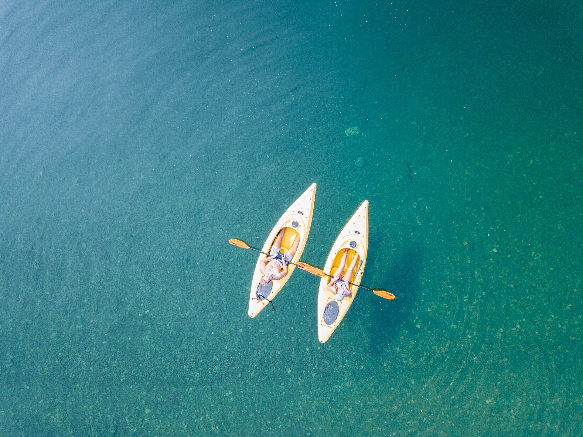 Un par de kayaks flotan sobre un cuerpo de agua.