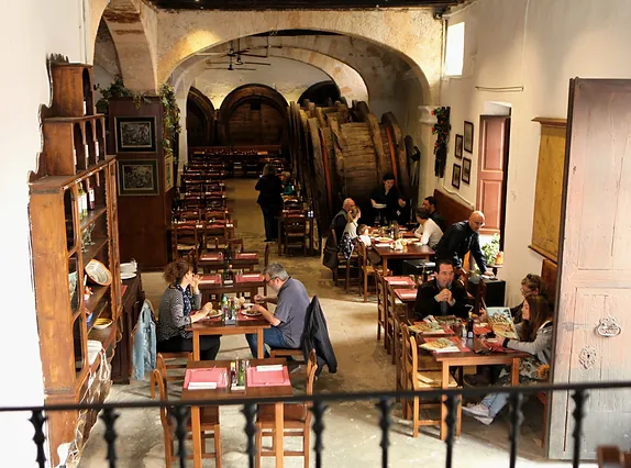 Un grupo de personas están sentadas en las mesas de un restaurante.