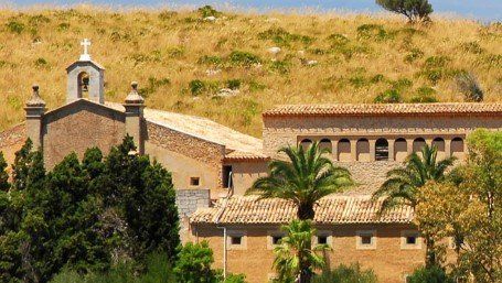 Hermitage on a hilltop with palm trees in front